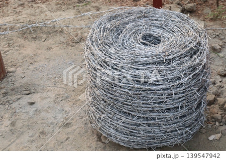 Real barbed wire on field for fence of garden 139547942