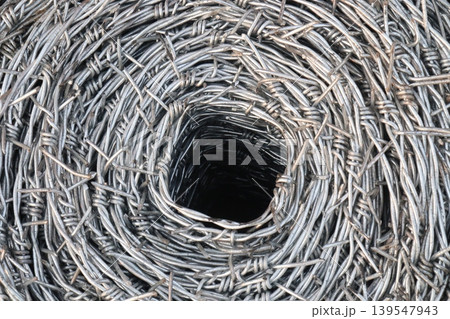 Real barbed wire on field for fence of garden 139547943