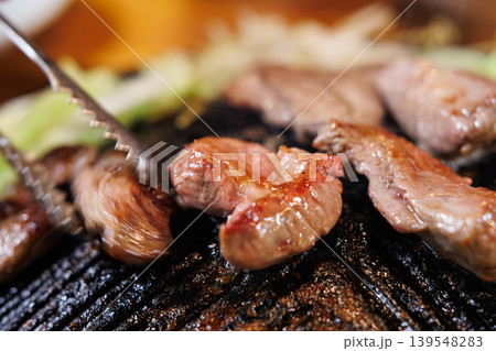 ジンギスカン鍋で焼いている途中のラム肉 ジンギスカン鍋で焼いている途中のラム肉 139548283