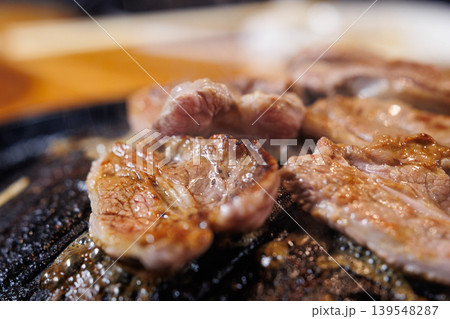 ジンギスカン鍋で焼いている途中の生ラム肉 139548287