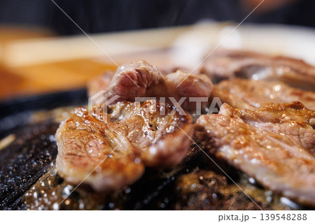 ジンギスカン鍋で焼いている途中の生ラム肉 ジンギスカン鍋で焼いている途中の生ラム肉 139548288