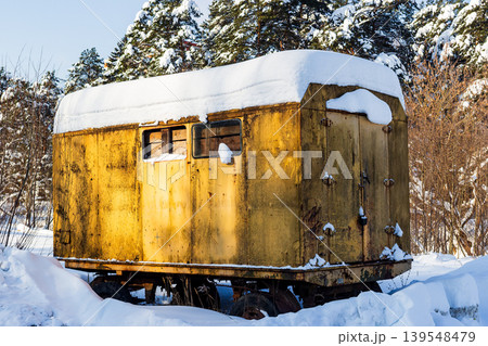 Abandoned, rusty construction trailer deep in a snowy northern forest. A weathered work hut, a stark symbol of forgotten times and harsh winter conditions at a remote site Abandoned, rusty construction trailer deep in a snowy northern forest. A weathered work hut, a stark symbol of forgotten times and harsh winter conditions at a remote site 139548479