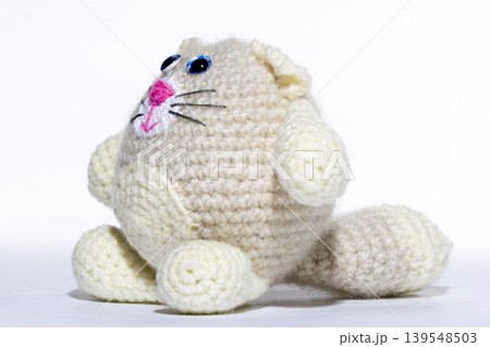 Knitted white cat on a white background Knitted white cat on a white background 139548503