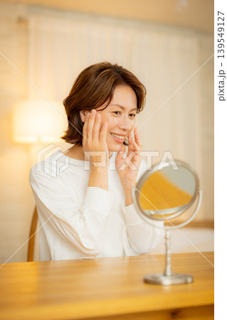 夜の寝室で肌の調子を気にする女性 139549127