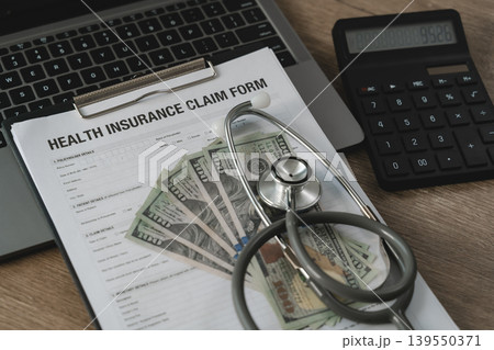 Health insurance claim form with stethoscope, calculator and cash on office desk. Concept of medical expenses, healthcare finance, insurance reimbursement and hospital billing management. 139550371