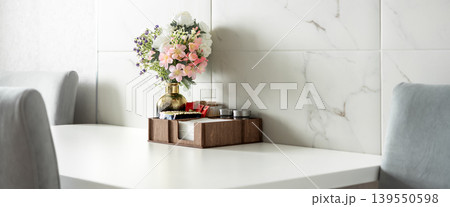 Dining table with flower vase in modern cafe interior Dining table with flower vase in modern cafe interior 139550598