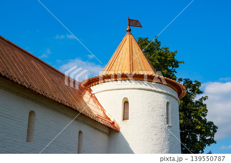 Classic white fort tower, topped with a brilliant copper conical roof and pennant, stark against a crisp blue sky 139550787