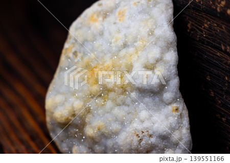Sparkling quartz druzy displays shimmering crystals, a captivating natural mineral specimen. Elegant texture on a dark, rustic wooden backdrop Sparkling quartz druzy displays shimmering crystals, a captivating natural mineral specimen. Elegant texture on a dark, rustic wooden backdrop 139551166