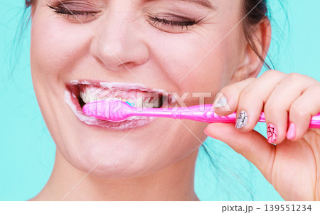 Woman brushing cleaning teeth 139551234