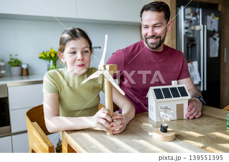 Father teaching daughter about renewable energy and ecology at home. Father teaching daughter about renewable energy and ecology at home. 139551395
