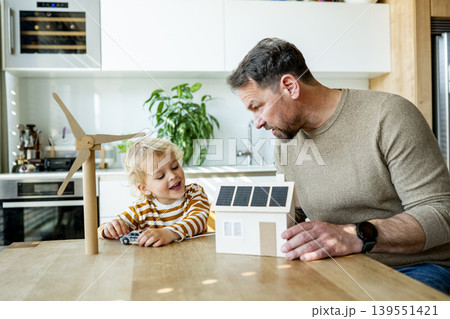 Father educating toddler about solar power and eco friendly living. Father educating toddler about solar power and eco friendly living. 139551421