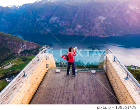 Tourist enjoying fjord view on Stegastein viewpoint Norway Tourist enjoying fjord view on Stegastein viewpoint Norway 139551479