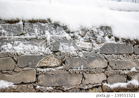 Aged brick wall texture, rugged and winter-worn, beautifully dusted with crisp white snow and frost. Perfect chilly background Aged brick wall texture, rugged and winter-worn, beautifully dusted with crisp white snow and frost. Perfect chilly background 139551521