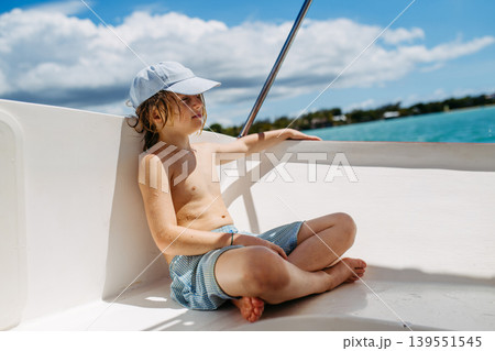 Child relaxing on boat during tropical family vacation. Child relaxing on boat during tropical family vacation. 139551545