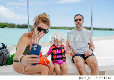 Family taking selfie together on boat during summer vacation. 139551548