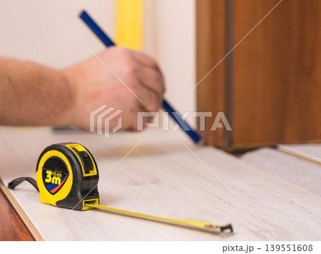 Man measuring floor panels 139551608