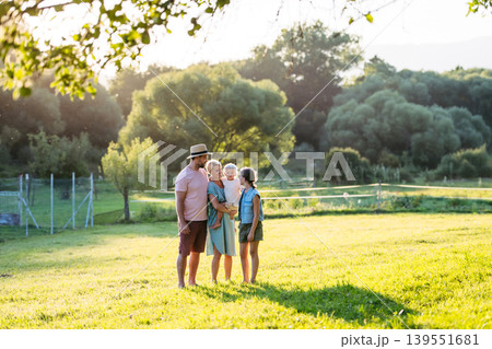 Family on walk in summer nature, standing in the middle of meadow. Family on walk in summer nature, standing in the middle of meadow. 139551681