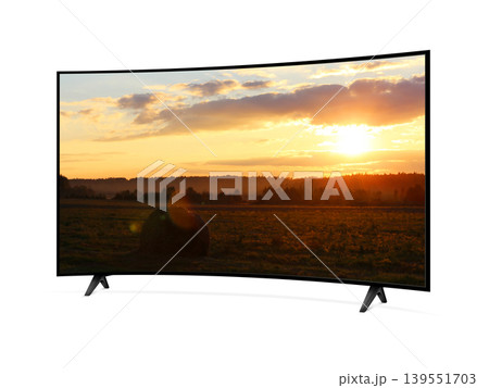 Curved screen tv from angled view with rural landscape with straw roll and sunset sky on screen 139551703