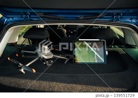 Professional drone equipment with tablet in car trunk ready for flying. Professional drone equipment with tablet in car trunk ready for flying. 139551729