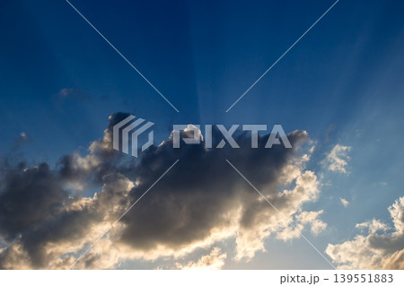 Sun rays on a background of blue sky and clouds during sunset Sun rays on a background of blue sky and clouds during sunset 139551883