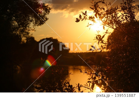 Bright orange sunlight during sunset over the river, beautiful highlights Bright orange sunlight during sunset over the river, beautiful highlights 139551887