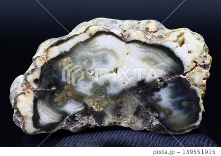 Polished slice of agate consisting of quartz and chalcedony on a dark background Polished slice of agate consisting of quartz and chalcedony on a dark background 139551915