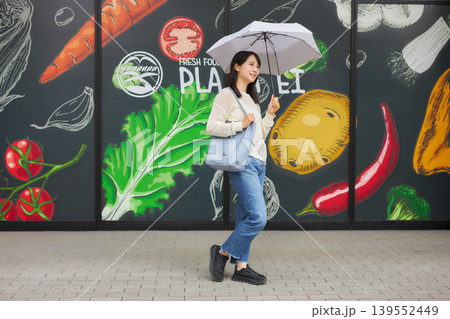 日傘をさしてスーパーマーケットへ行く若い女性 日傘をさしてスーパーマーケットへ行く若い女性 139552449