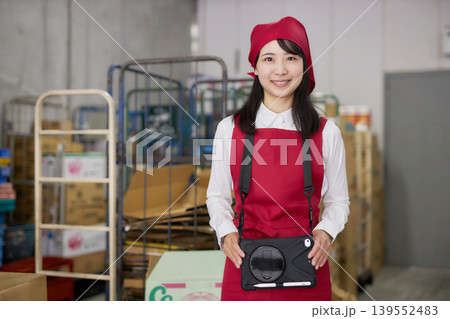 バックヤードでタブレットで商品管理をする若い女性 バックヤードでタブレットで商品管理をする若い女性 139552483