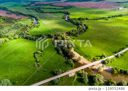 View from a high altitude of a landscape with a river and an oxbow surrounded by green fields View from a high altitude of a landscape with a river and an oxbow surrounded by green fields 139552486