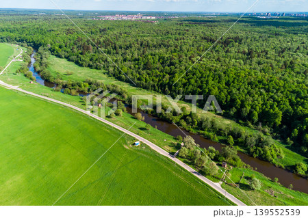 View from a high altitude of a green landscape with a field, river and forest. Water wells located along the river outside the city limits View from a high altitude of a green landscape with a field, river and forest. Water wells located along the river outside the city limits 139552539
