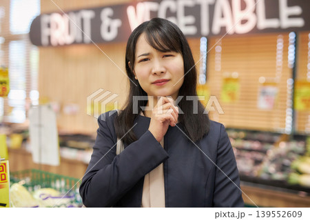 仕事帰りにスーパーマーケットで買い物をする若い女性 仕事帰りにスーパーマーケットで買い物をする若い女性 139552609