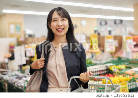 仕事帰りにスーパーマーケットで買い物をする若い女性 仕事帰りにスーパーマーケットで買い物をする若い女性 139552612