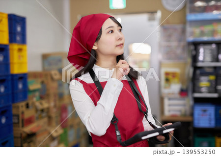 バックヤードでタブレットで商品管理をする若い女性 139553250