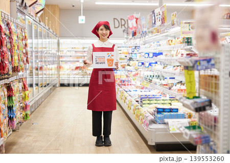 スーパーマーケットの商品の前で食品ロスのプラカードを持つ若い女性 スーパーマーケットの商品の前で食品ロスのプラカードを持つ若い女性 139553260