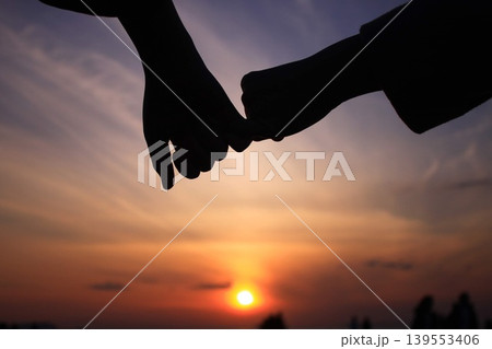 夕日を背景に手をつなぐ二人 夕日を背景に手をつなぐ二人 139553406