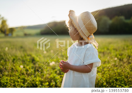 Cute girl playing on meadow, in spring nature. Cute girl playing on meadow, in spring nature. 139553780