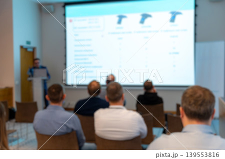 Blurred audience in conference room watching presentation Blurred audience in conference room watching presentation 139553816