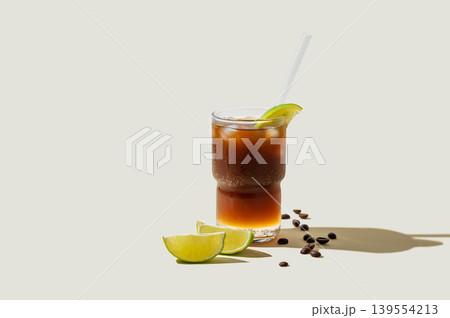 Cold Coffee Tonic Drink With Lime and Ice on light background with shadows 139554213