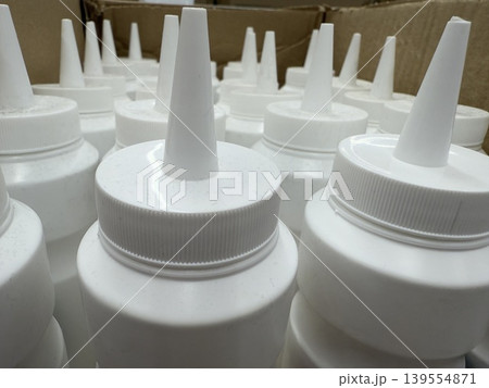 Plastic squeeze bottles with pointed nozzles in cardboard box, suitable for storage background Plastic squeeze bottles with pointed nozzles in cardboard box, suitable for storage background 139554871