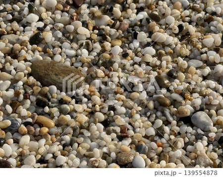 Pebbles of various sizes and colors on a beach, creating a natural texture background 139554878