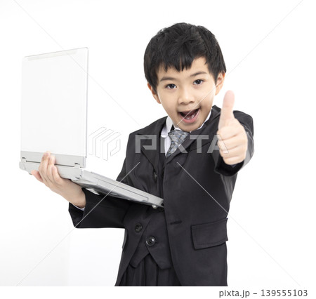 Happy boy gives thumbs up while using laptop Happy boy gives thumbs up while using laptop 139555103