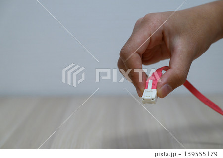 ピンクのLANケーブルを持つ手 ピンクのLANケーブルを持つ手 139555179