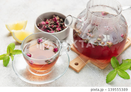 Pouring fragrant rose tea into a transparent cup Pouring fragrant rose tea into a transparent cup 139555389