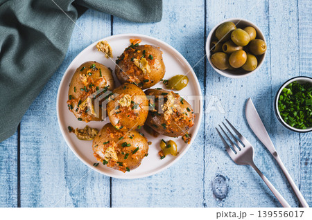 Baked new potatoes with herbs and olives on a plate on the table top view Baked new potatoes with herbs and olives on a plate on the table top view 139556017