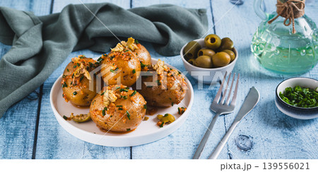 Baked new potatoes with herbs and olives on a plate on the table web banner Baked new potatoes with herbs and olives on a plate on the table web banner 139556021