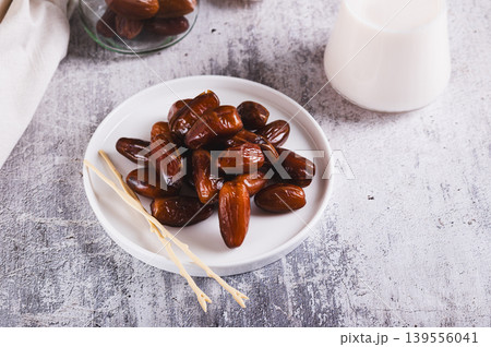 Healthy fresh dates in a bowl and milk in a glass on the table Healthy fresh dates in a bowl and milk in a glass on the table 139556041