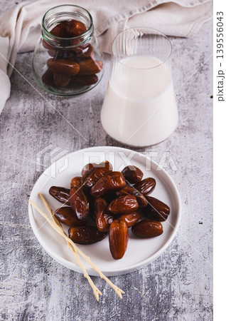 Healthy fresh dates in a bowl and milk in a glass on the table vertical view 139556043