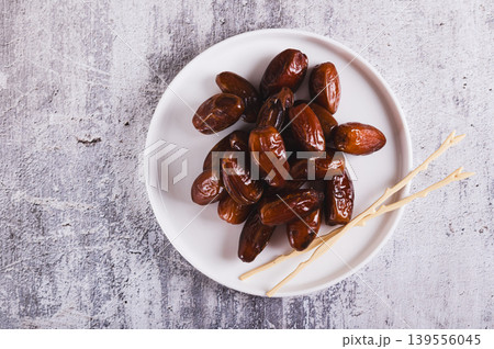 Close up of sweet dates on a plate and sticks on the table top view 139556045