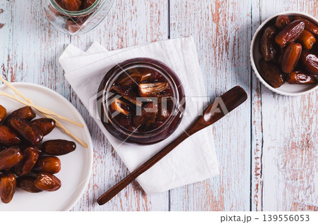 Sweet date marmalade in a jar and fruit in a bowl on a table top view Sweet date marmalade in a jar and fruit in a bowl on a table top view 139556053