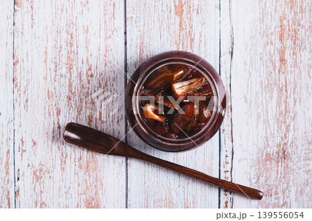 Close up of sweet date marmalade in a jar and spoon on a table top view 139556054